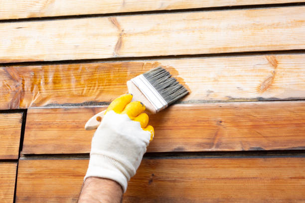 Brushing fresh stain onto pine boards